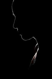 An Ode to Darkness - shows the outline or silhouette of the profile of a person's head/torso.